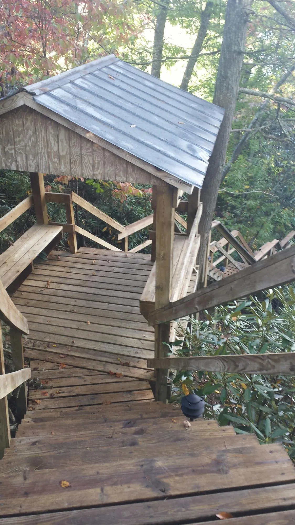 Metal roofed shelter over wooden steps on a wooded walkway — Skylight Repair & Installation work by our crew in New Suffolk