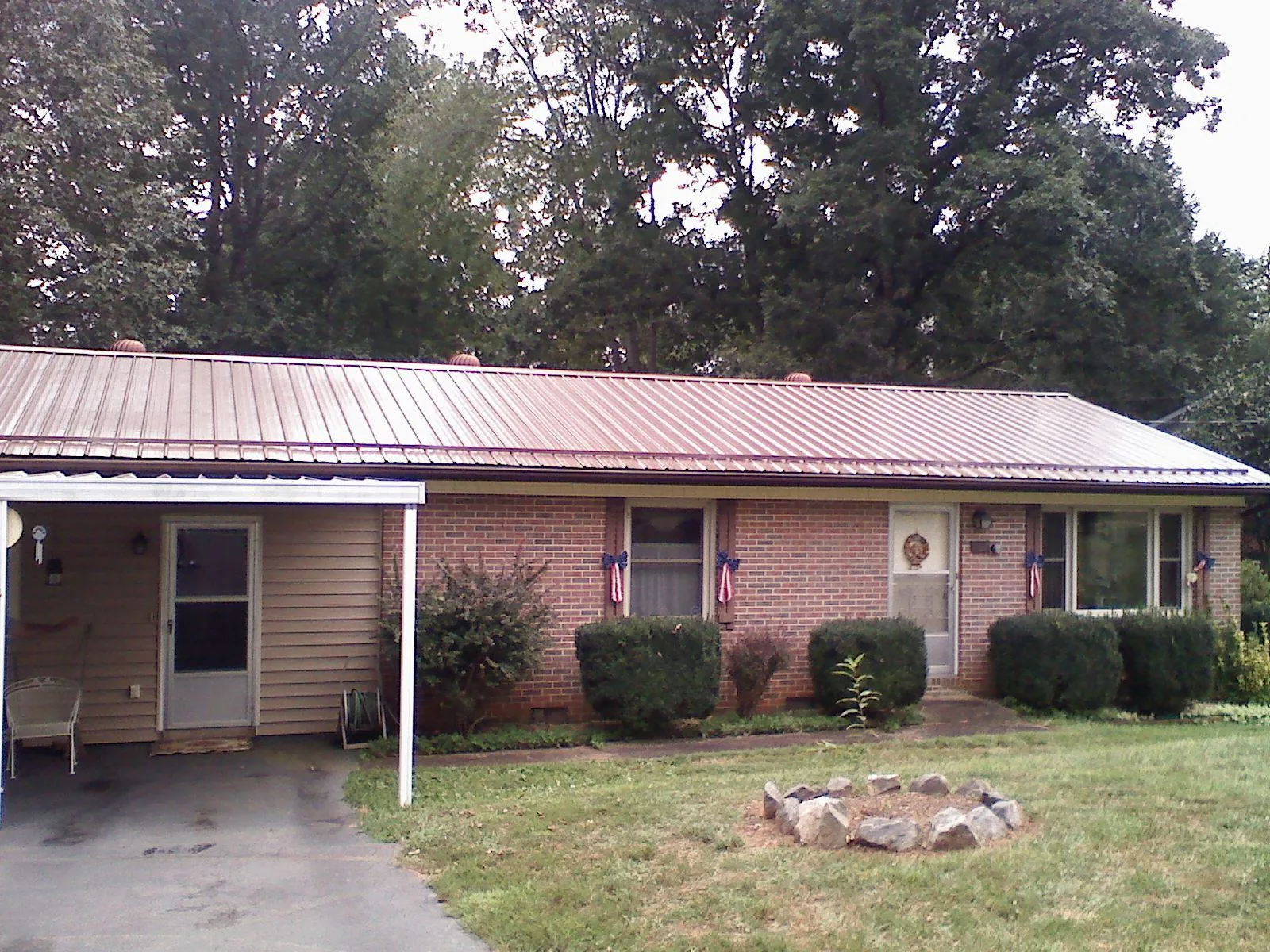 Bronze metal roof and carport on a brick ranch home — Roof Repair work by our crew in New Suffolk